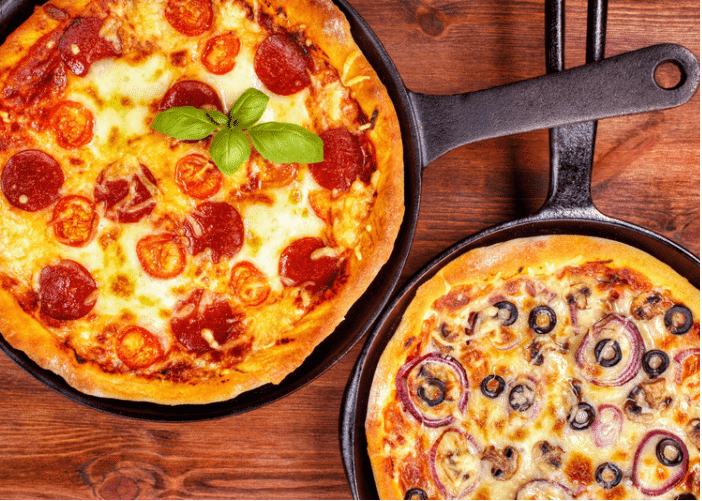 Two colorful pizzas in pans