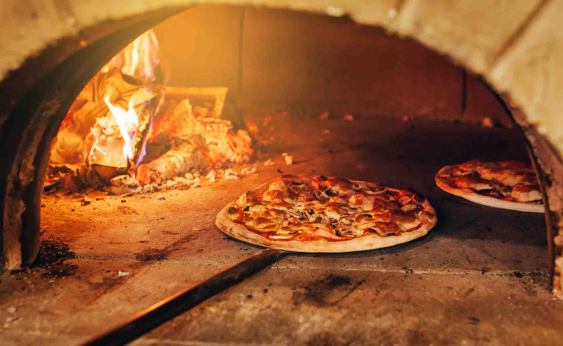Pizza baking in the wood-fired oven