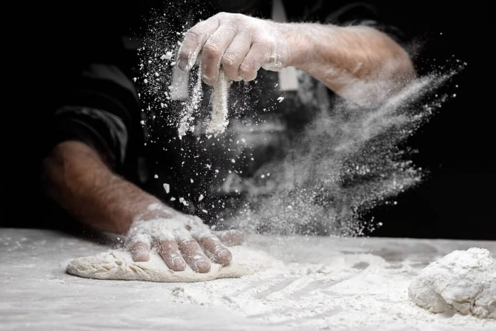 Person preparing pizza dough
