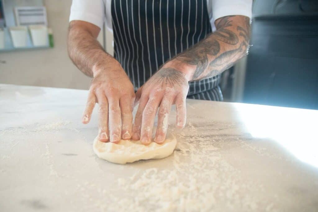 A chef stretching out pizza dough