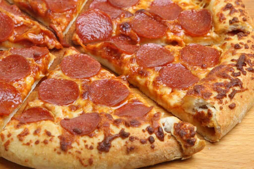 Sliced pepperoni pizza with a sauce-filled crust