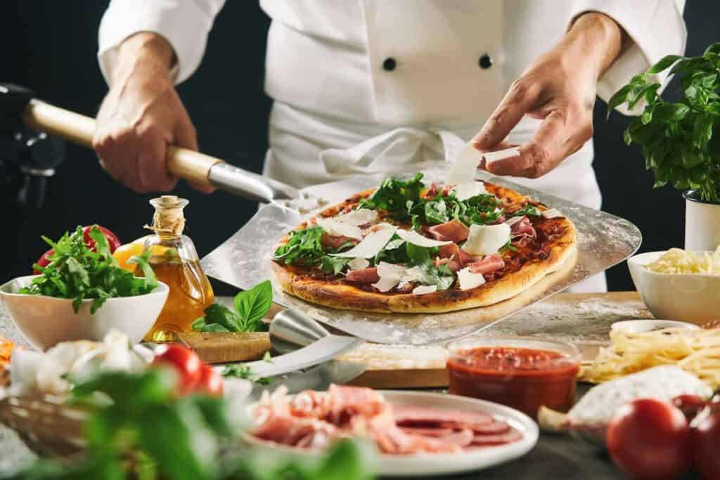 Chef placing a baked pizza on the table