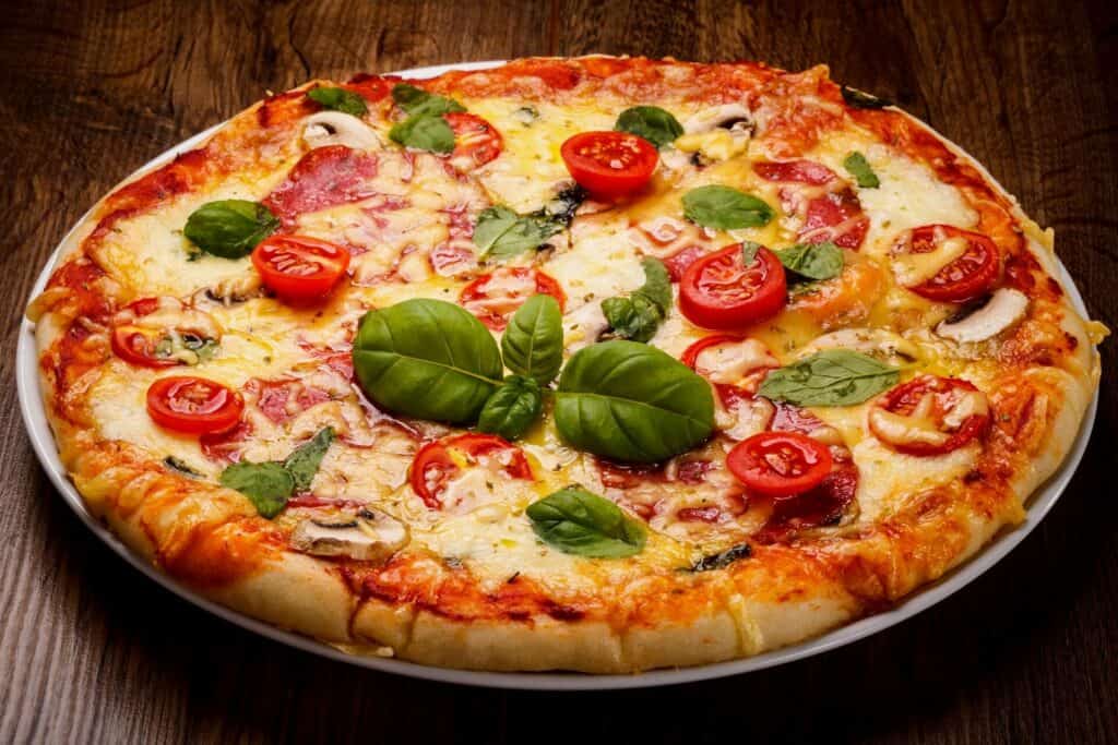 Pizza topped with tomatoes, basil, cheese, and pepperoni