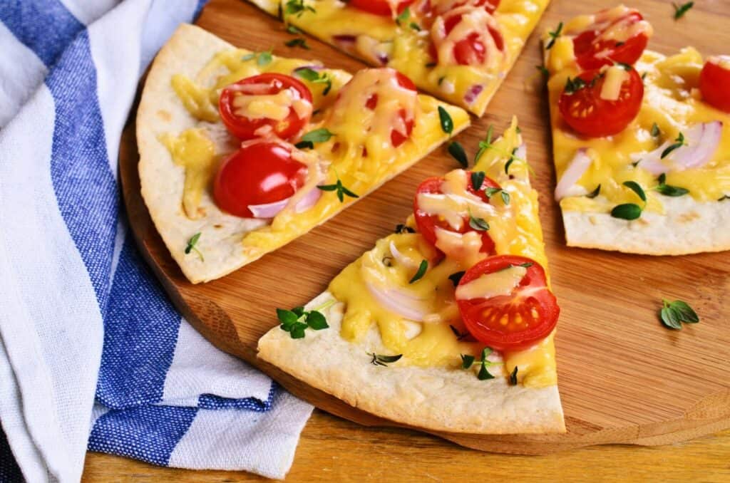 Slices of a cheese pizza with tomatoes