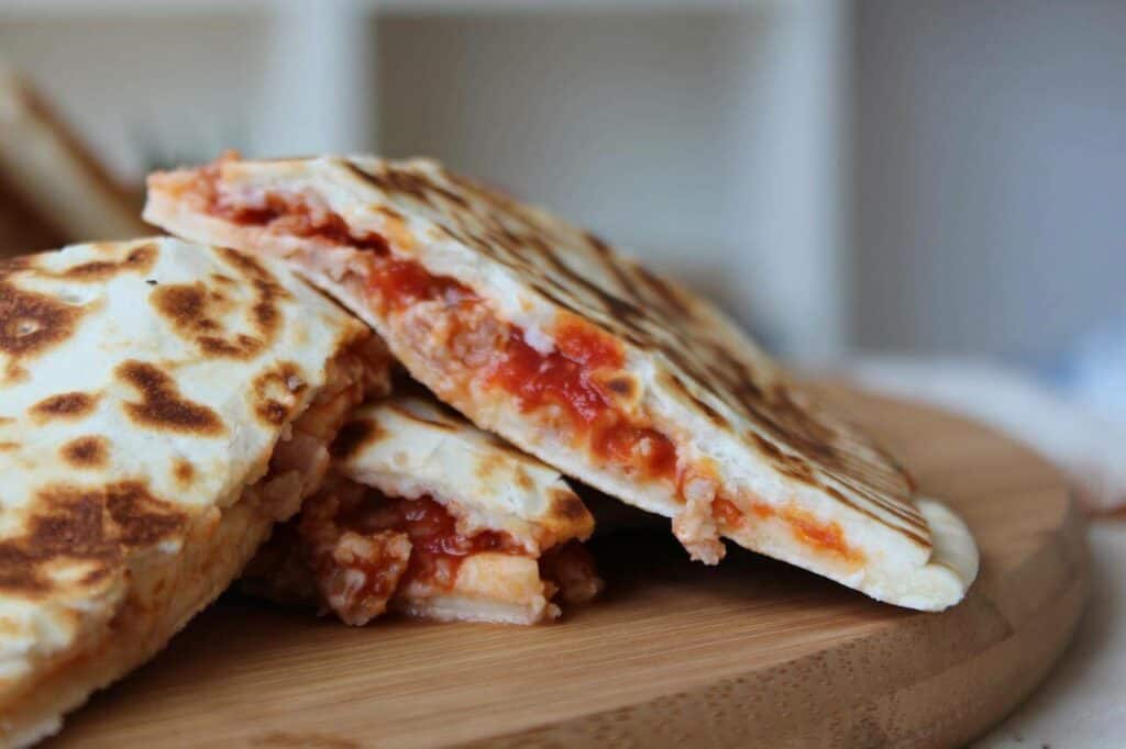 Calzones with tomatoes stacked on a plate