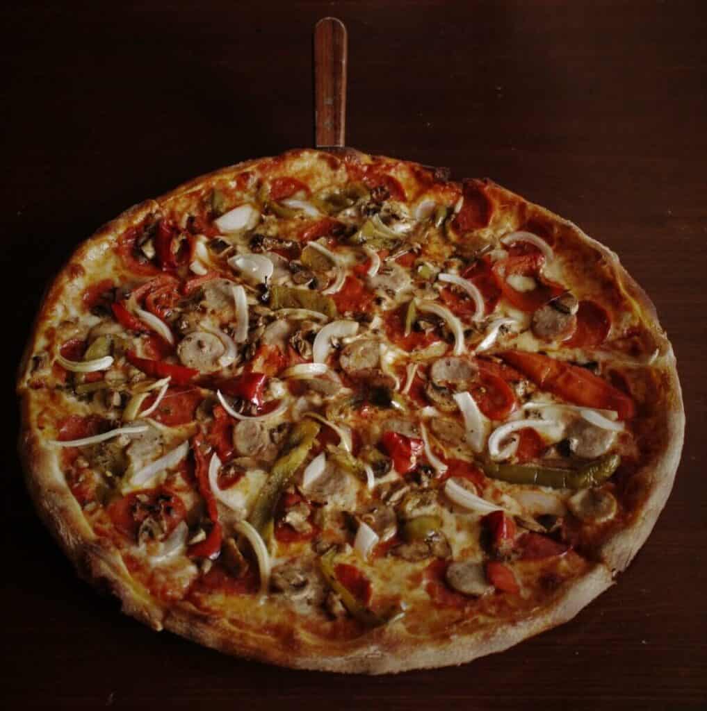 A pizza with onions and peppers