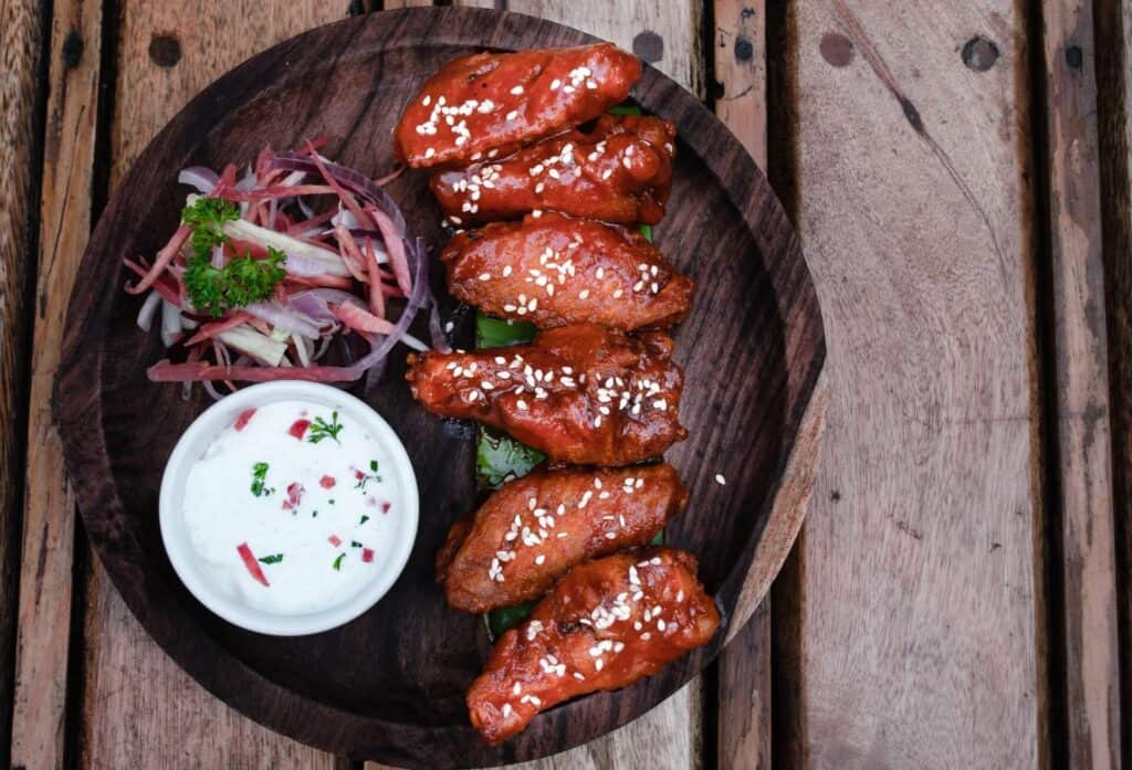 A serving of buffalo wings on a wooden platter