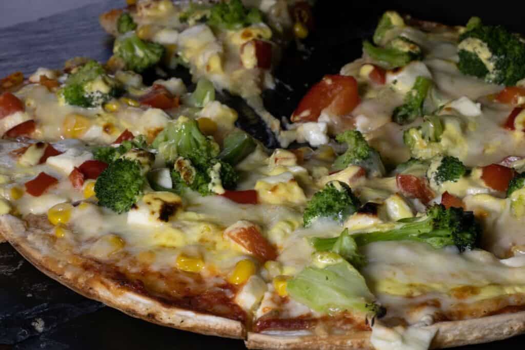 Pizza with melting cheese and vegetables