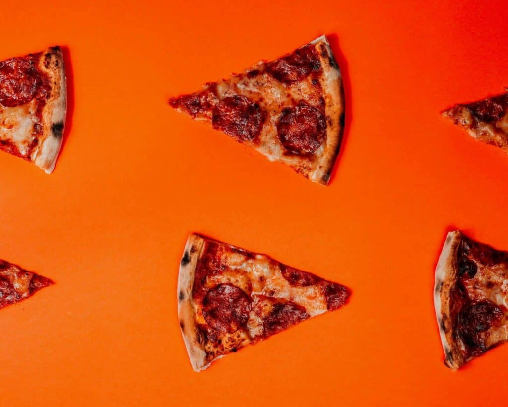 Pizza slices randomly placed on an orange background