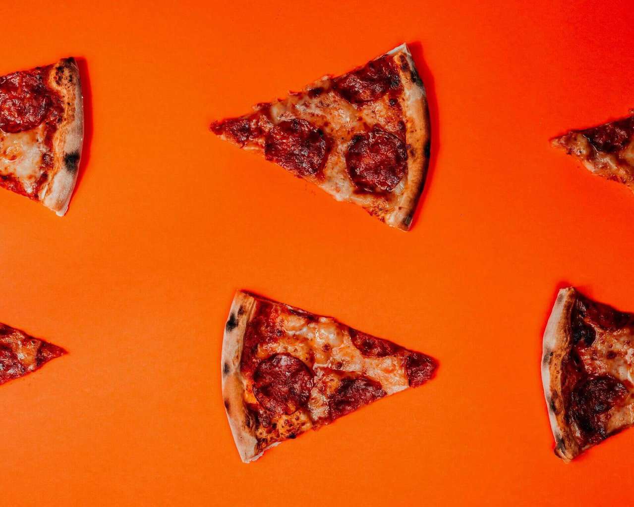 Slices of pizza on orange background