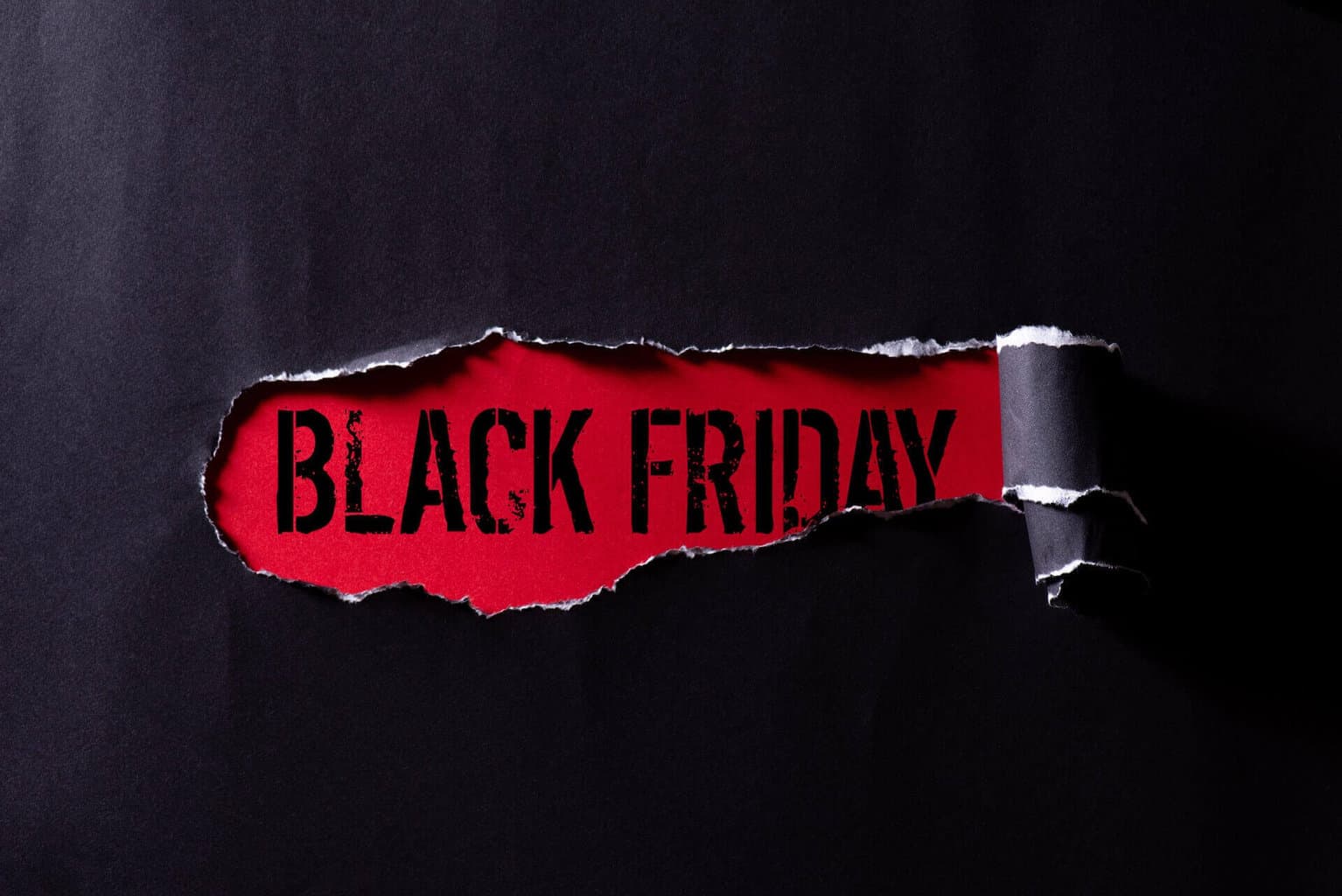 Black torn paper and the text "Black Friday" on a red background