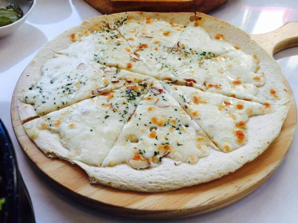 Cheese pizza on a wooden platter
