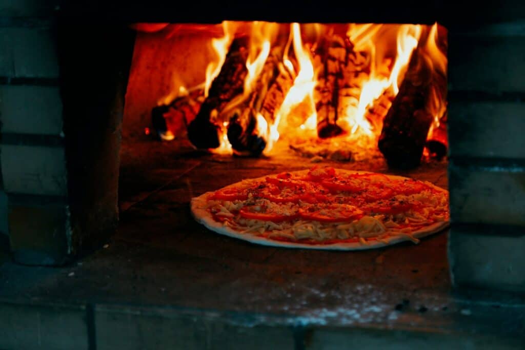 Pizza baking inside of a wood-fired oven