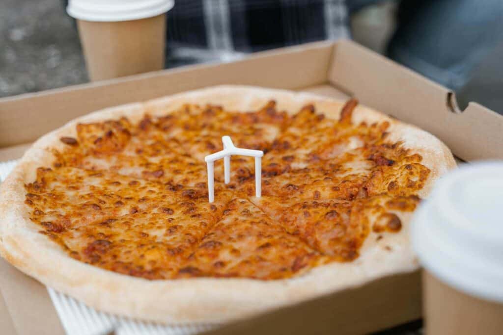 Pizza with cheese toppings in a box