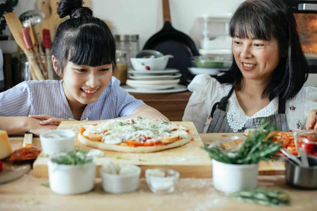 Two women looking at a pizza on a wooden board