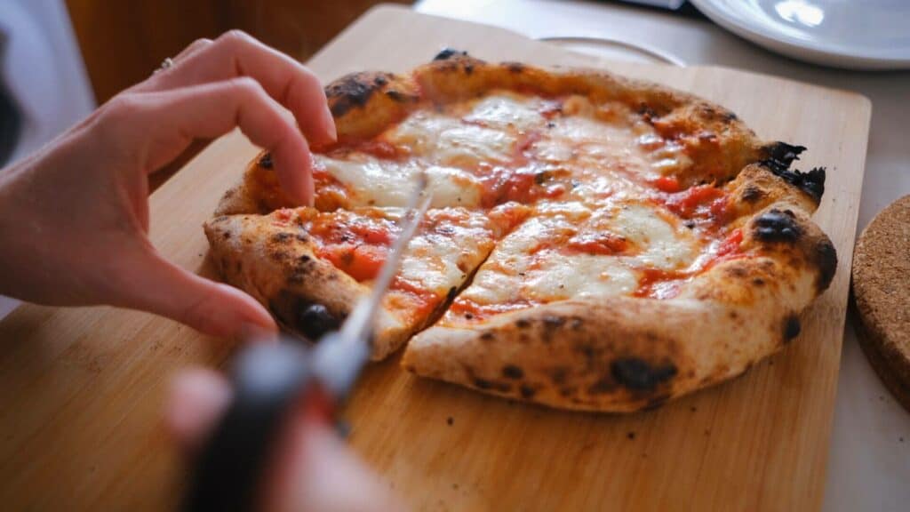 Person slicing a pizza