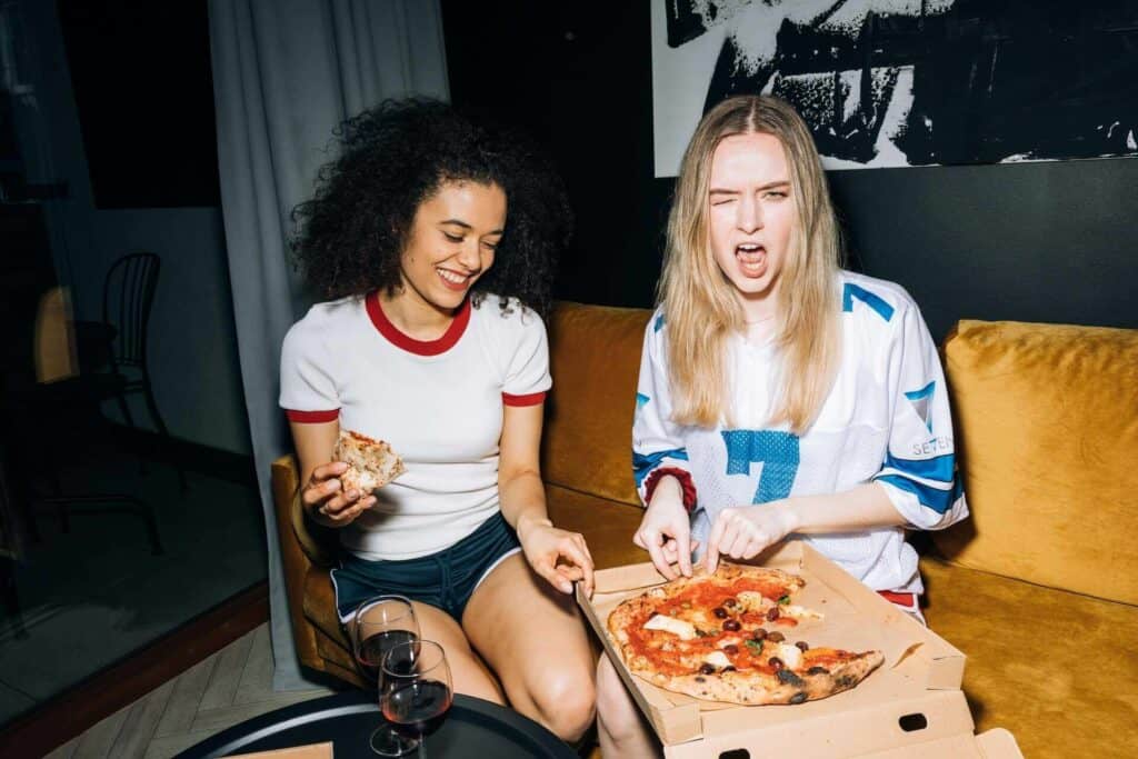 Two young women eating a pizza